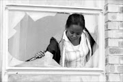 SHATTERED: Resident Maite Matima looks through the broken window suspected to have been used by illegal Zimbabweans to get into her house in Serala View, Polokwane. Pic: ELIJAR MUSHIANA. 19/11/2009. © Sowetan.