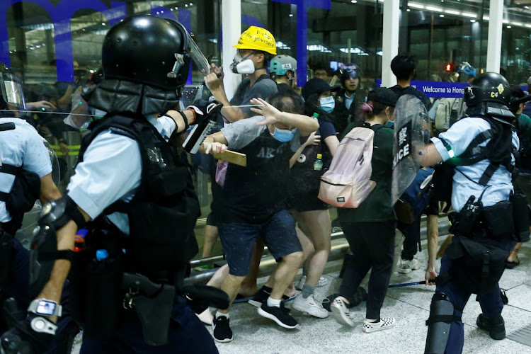 A police officer sprays pepper spray at anti-government protesters during clashes at the airport in Hong Kong, China, on August 13 2019. Picture: REUTERS/THOMAS PETER