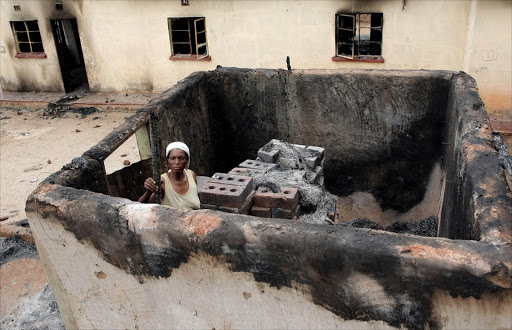 November 09, 2016. Joyce Mphethi , who carried her ill 60-year-old-father out of their home when they came under attack at GaMphethi in Limpopo, inspects the damage to their property.Photo: SANDILE NDLOVU © Sowetan