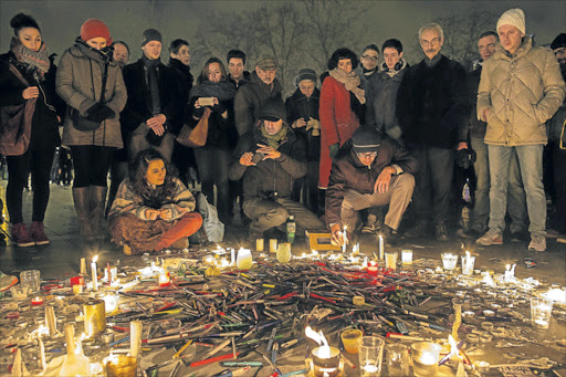 Pens are thrown on the ground as people hold a vigil at the Place de la Republique (Republic Square) for victims of the terrorist attack, on January 7, 2015 in Paris, France