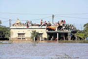 Residents seek refuge on rooftops to escape the flood waters in Chokwe, Mozambique Picture: FERHAT MOMAD