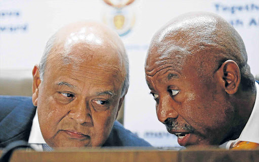 BACK IN THE HOT SEAT: Finance Minister Pravin Gordhan, left, chats to SA Reserve Bank governor Lesetja Kganyago during a media briefing after Gordhan was re-appointed to the position on Sunday night by President Jacob Zuma after public outcries over his appointment of David van Rooyen Picture: REUTERS
