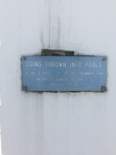 This plaque in affixed to one of the arches, overlooking the ponds and fountains. It reads, "Coins thrown into pools become a part of the building endowment fund. Unauthorized removal of coins is...