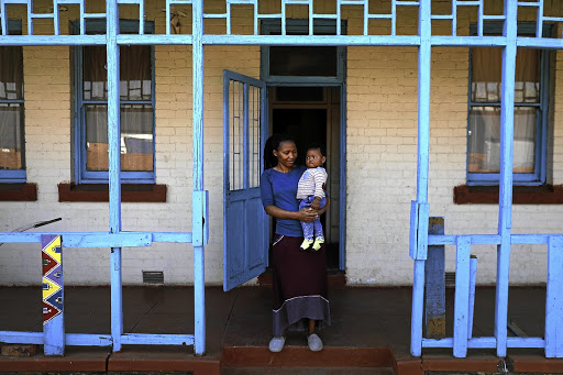 Yonela Mkalipi and her son, Omphile Makubung, outside their home in Crown Mines village.