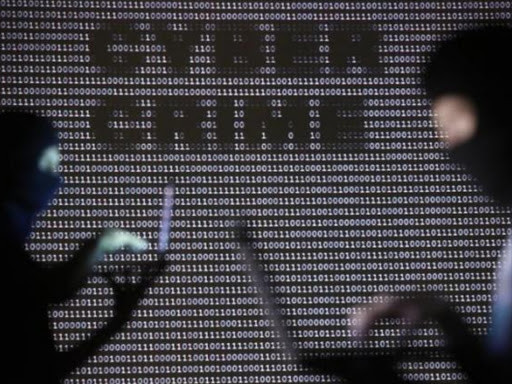 People wearing balaclavas are silhouetted as they pose with a laptops in front of a screen projected with the word 'cyber crime' and binary code, in this picture illustration taken in Zenica October 29, 2014. Photo/REUTERS
