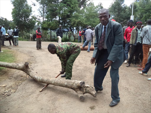 Security officers from Kabartonjo, Baringo North Sub-county led by Deputy Commissioner Micah Ondoro (in suit) assists in removing barricades put by protesters on Tuesday. PHOTO/JOSEPH KANGOGO