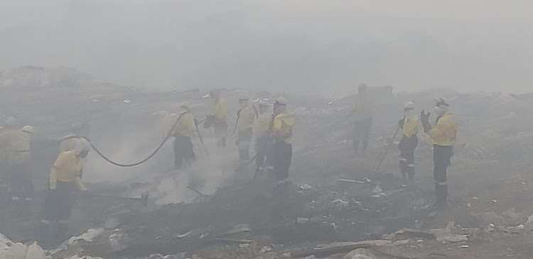 Firefighters work through the thick, smoke-filled air at the New England Road landfill site in Pietermaritzburg, where a fire has burnt for several days.