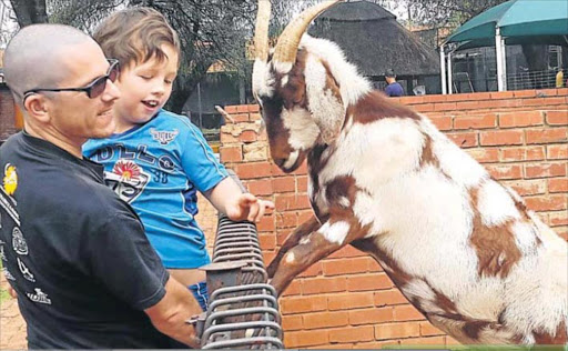 BONDING: Brendan, 8, with dad Tim Stones, at a Pretoria touch farm in March Picture: SUPPLIED