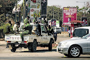 HIGH ALERT: Zambian police officers patrol the streets of the capital Lusaka after disputed presidential election results. Opposition party leaders have claimed that the results were rigged, leading to  protests in the country   PHOTO: GIANLUIGI GUERCIA/afp