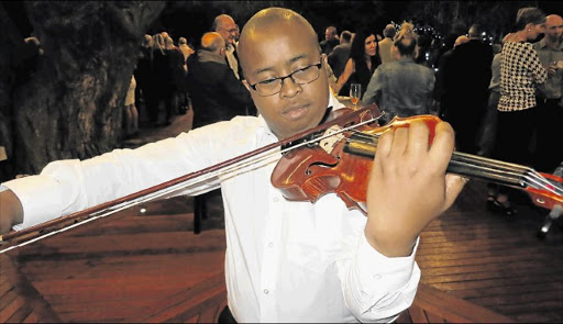 JOB DUET: Zweli Daniel, 30, entertains guests at the launch on Tuesday night of the Olivewood Private Estate & Golf Club near Chintsa. Daniel, who is a qualified electrical engineer, designs electrical reticulation systems for local schools Picture: MIKE LOEWE