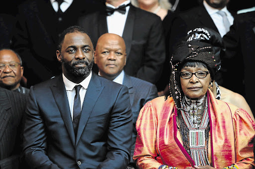 Idris Elba, who stars as Nelson Mandela in 'Mandela: Long Walk to Freedom', sits next to Mandela's real-life ex-wife, Winnie Madikizela-Mandela, at the film's premiere in Rosebank, Johannesburg, yesterday. Behind them is Justice Minister Jeff Radebe