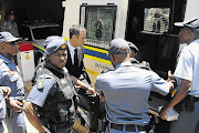 Oscar Pistorius enters a police van after being sentenced to five years in prison for killing his girlfriend Reeva Steenkamp.