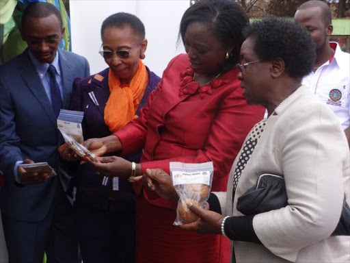 Jomo Kenyatta University of Agriculture and Technology Vice Chancellor Prof Mabel Imbuga, Kiambu County women representative Anna Nyokabi, JKUAT's DVC in charge of Research, Production and Extension Prof Esther Kahangi and researcher admire cricket products made at the institutions by researchers.