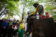 People visit the monument dedicated to Ayrton Senna during an event to commemorate the 30th anniversary of Ayrton Senna's death at Autodromo Enzo e Dino Ferrari on May 1 2024 in Imola, Italy. Brazilian F1 racing driver Senna, and Austrian Roland Ratzenberger both lost their lives on the same weekend in crashes at the 1994 San Marino Grand Prix.