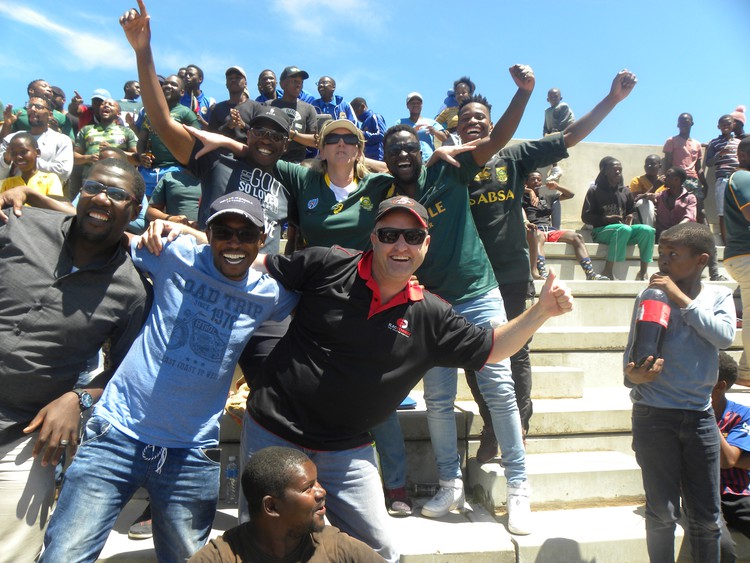 Black, white, immigrant and local – people from all walks of life gathered in Zwide Stadium to watch the Springboks win the 2019 Rugby World Cup. Sue Hagemann and Masakhane Mlamla are in the middle wearing the Springbok jerseys.
