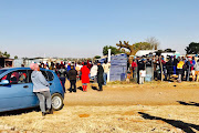 People queue with their ID documents to be registered by members of the EFF for a piece of land in Brakpan on June 22 2018 