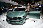 A model poses next to a Kia Motor's concept car Novo at the Seoul Motor Show 2015 in Goyang in this April 3, 2015 file photo. Kia Motors plans to launch its first sports sedan next year, people familiar with the matter told Reuters, seeking to burnish a sporty, younger image as larger sibling Hyundai Motor builds up its premium offerings.  REUTERS/Kim Hong-Ji/Files