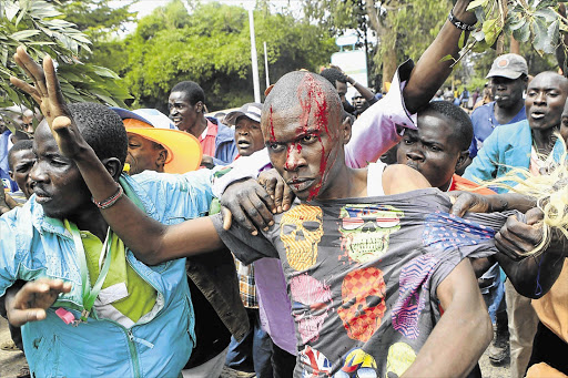 COUNTRY OF MY SKULL: Supporters of Kenya's opposition Coalition for Reforms and Democracy after a run-in with riot police at a 'Saba Saba Day' rally in Nairobi yesterday. Police fired teargas to disperse a crowd of a few hundred anti-government demonstrators