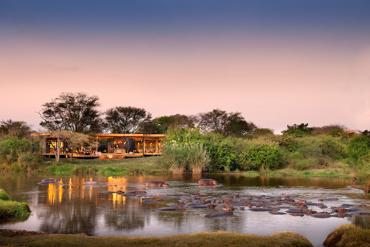 Tanzania Grumeti Serengeti River Lodge guest area with view of hippo pod.