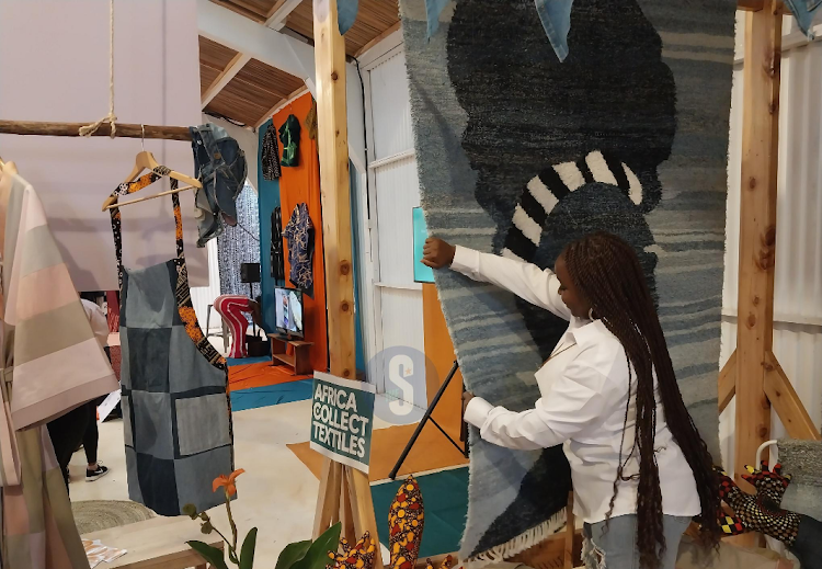 Natalie Botango displays a mat made by upcycling of denim materials, which were disposed during the Nairobi Design Week