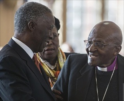 Former South African President Thabo Mbeki (L) shakes hands with Archbishop Desmond Tutu during the wedding vow renewal ceremony of Desmond Tutu and his wife Nomalizo Leah at the Holy Cross Anglican Church in Orlando, western Soweto, near Johannesburg, on July 4, 2015. AFP PHOTO / MUJAHID SAFODIEN