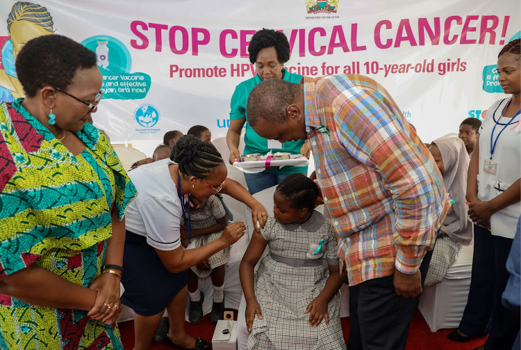 The human papillomavirus vaccine is administered to a 10-year-old girl during the launch of the HPV vaccine campaign at Ziwani Primary School, Mombasa, as then Health CS Sicily Kariuki and then President Uhuru Kenyatta look on, in 2019.