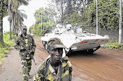 A UN peacekeepers' armoured vehicle drives past rebels patrolling a street in Goma, in the eastern Democratic Republic of Congo, soon after capturing the city from the government army.