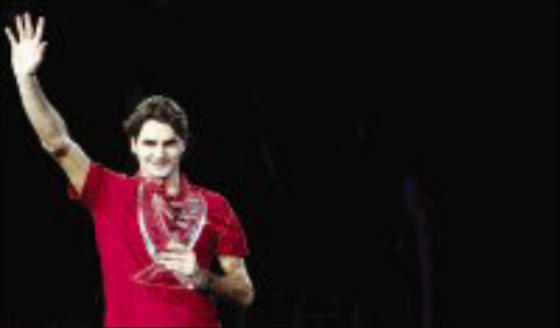 VIRTUOSO: Roger Federer of Switzerland poses with the trophy after winning the Masters Cup tennis tournament in Shanghai yesterday. Pic. Nir Elias. 18/11/07. © Reuters.