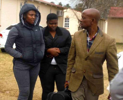 IN HOT WATER: Nyameka Qongqo, left, and her sister Thumeka, during their arrest in Queenstown Picture: ABONGILE MGAQELWA