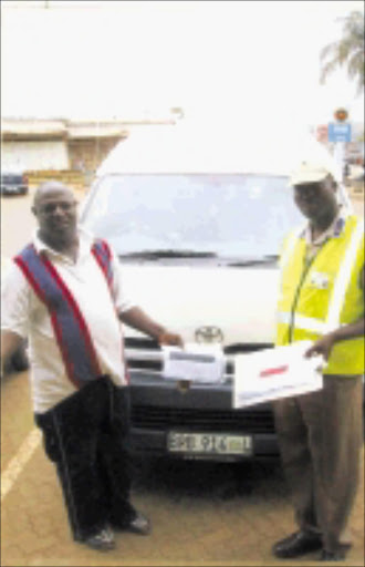 IN DISPUTE: Sefofa shows a cop papers for his impounded taxi. Pic. Unknown.