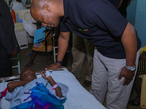 Safaricom Foundation Trustee, Stephen Chege comforts patient Rose Wambui, a beneficiary of Free Ear Surgeries supported by Safaricom Foundation at the Nanyuki Teaching and Referral Hospital.