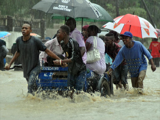 Youths in Bamburi mwisho ferry residents using carts May 11 after a heavy down pour,transport system was highly affected.Photo/John Chesoli