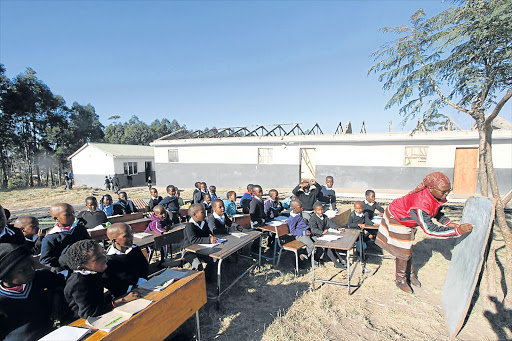 HARD WORK: Pupils at Ngwenyeni JSS near Flagstaff have endured tough conditions for their midyear exams since a wind blew their classroom roof off about a week ago