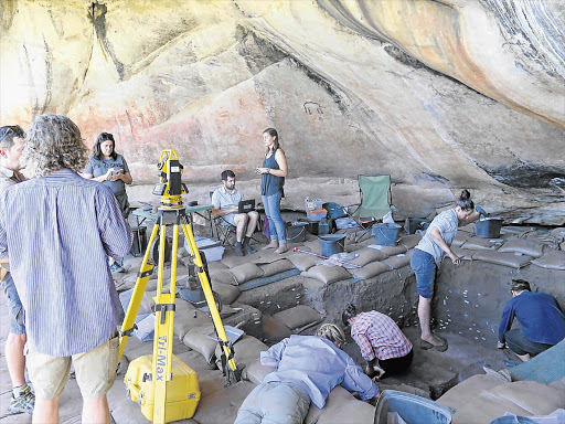 BONING UP OUR KNOWLEDGE: Archaeologists in the Cederberg Mountains, Western Cape, discovered a child's remains where there is a ledge in the pit. The white labels mark where artefacts have been removed from the pit walls