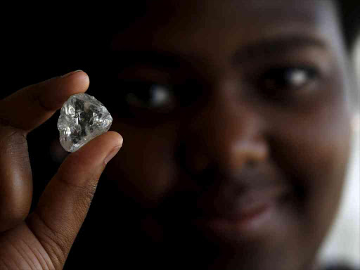 A visitor holds a diamond during a visit to the De Beers Global Sightholder Sales (GSS) inGaborone, Botswana November 24, 2015 /REUTERS