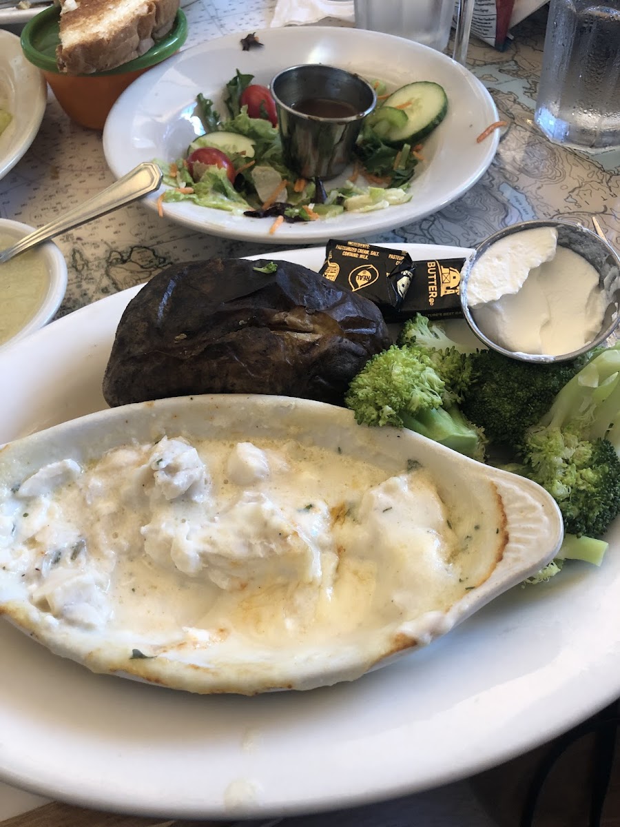 Dishes with cheese, baked potato, broccoli and garden salad