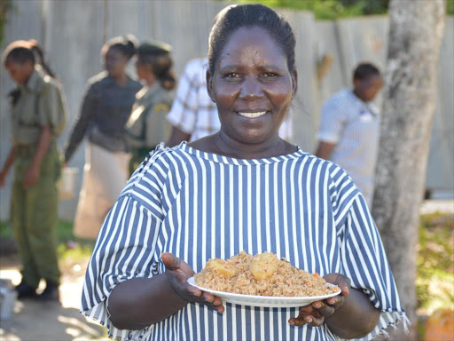 An inmate at Shimo la Tewa women’s prison carries a plate of pilau during the visit by Virtual Volunteers Foundation on Easter Sunday / CHARLES MGHENYI
