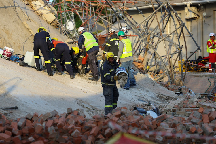 Rescue workers remove rubble from the site.