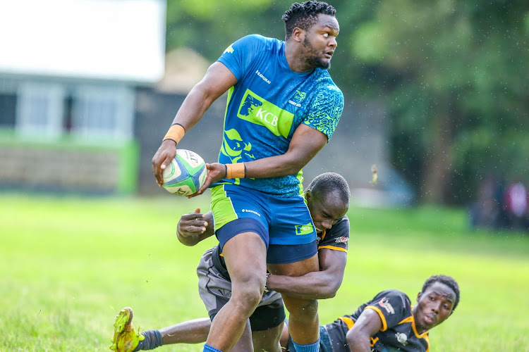 Kolian Persian of KCB RFC, brushes past CUEA rugby players during the Enterprise Cup opening match on April 20, 2024.
