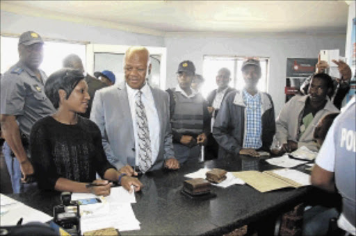 IN THE FRONT LINE: Minister in the Presidency Jeff Radebe paid an unannounced visit to Etwatwa police station in Ekurhuleni where he spoke to Nompumelelo Mace, who was attended to by a police officer on duty PHOTO: BAFANA MAHLANGU