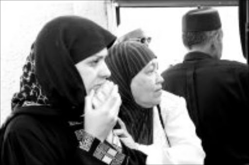 SHATTERED: Jolene Rossier, left, is comforted by relatives after her two sons and father were burnt to death in her house in Newclare, Johannesburg. Pic. Lucky Nxumalo. 22/07/07. © Sowetan.