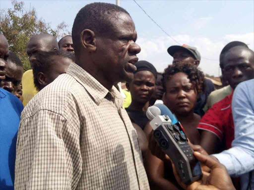 Nyalenda sublocation assistant chief David Rajoro addresses the media outside the house where a woman was found dead on the morning of October 17, 2016. /FAITH MATETE
