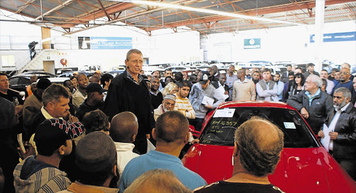 Eager car buyers on the lookout for good deals at an auction