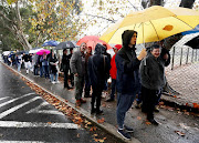 A lengthy queue formed in the rain outside the polling station at Claremont Primary School in Cape Town. 
