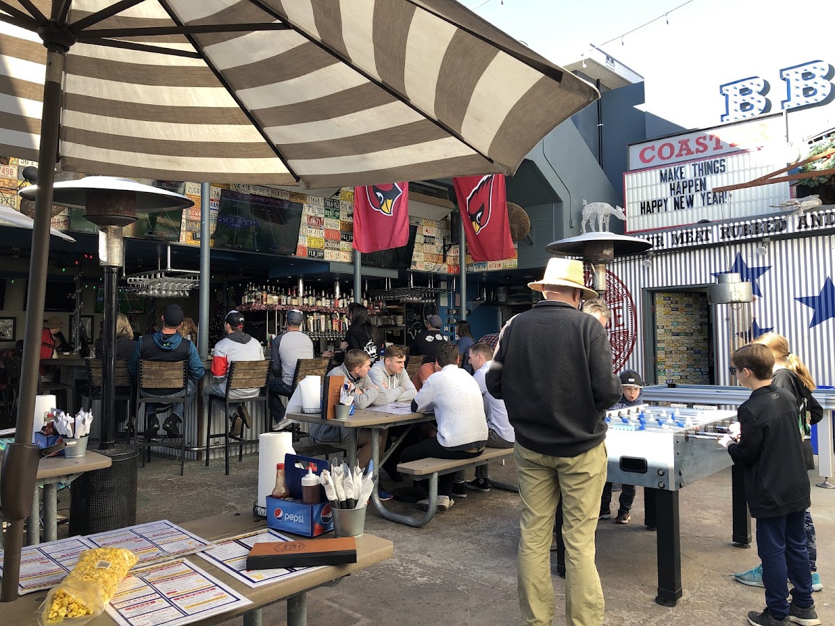 Indoor/outdoor sports bar with cornhole, Jenna, football, etc. gluten free items marked on menu.