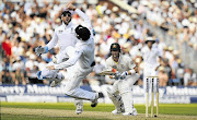 Australia's captain Michael Clarke, right, watches as England's Matt Prior (left, facing camera) and Ian Bell try in vain to catch a ball as Australia got on top in the third Ashes Test match at Old Trafford in Manchester yesterday