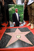 A person holds a picture of rapper Tupac Shakur next to his star during its posthumous unveiling ceremony on the Hollywood Walk of Fame in Los Angeles on June 7 2023.