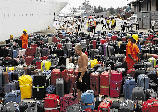 A passenger looks for his bags after alighting from the ill-fated Costa Allegra cruise ship at Mahe port in Seychelles yesterday. The crippled cruise liner, with more than 600 passengers on board, arrived at the Seychelles capital after three days of 'sheer hell' Picture: REUTERS