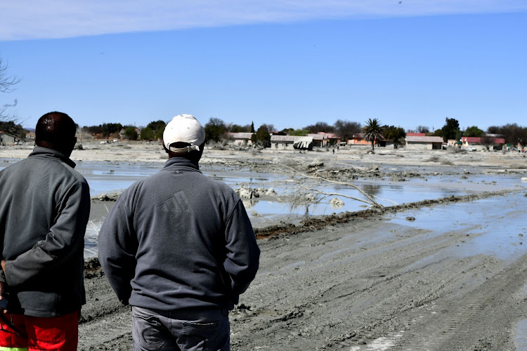 Jagersfontein residents look at the damage caused by the mine's tailings dam wall collapse.
