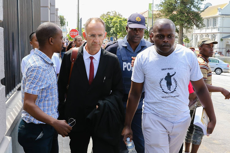 Rape accused charismatic Nigerian pastor Timothy Omotoso's defence attorney Peter Daubermann leaves the Port Elizabeth High Court under a police guard.